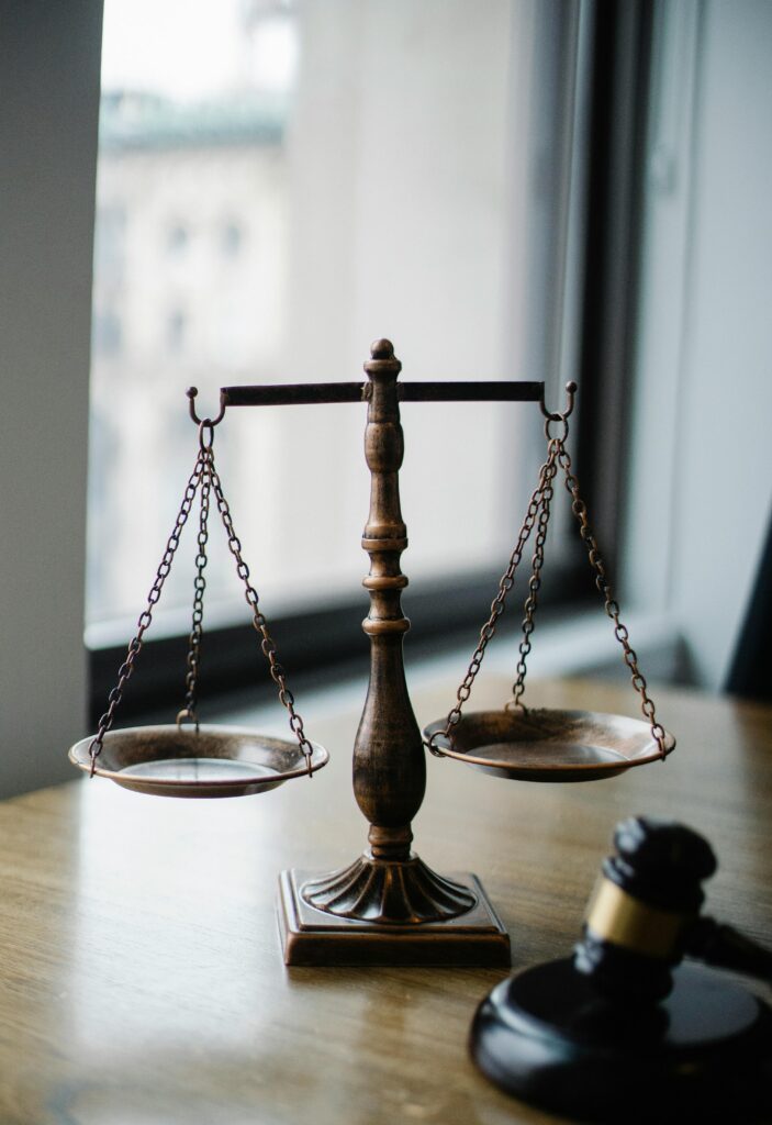 Accueil Decorative judgement scale and gavel placed on desk in light lawyer office against window